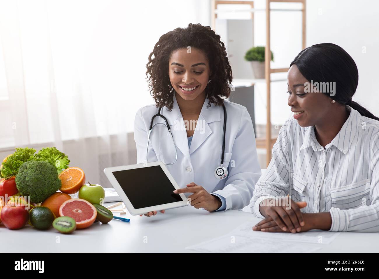 Dietologist using digital tablet in office, making patient's anamnesis Stock Photo