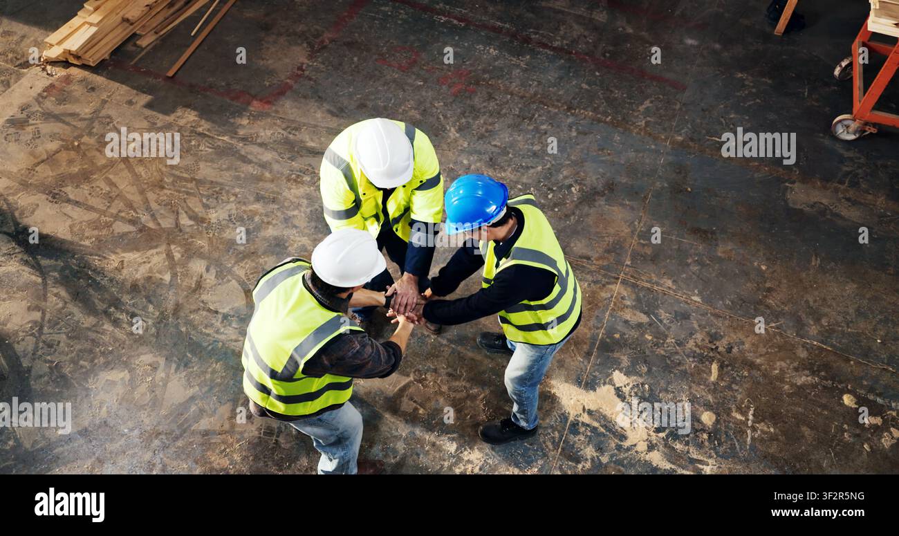 Above, success and men with hand stack for carpentry, construction project and agreement. Happy, teamwork and people with support for renovation Stock Photo