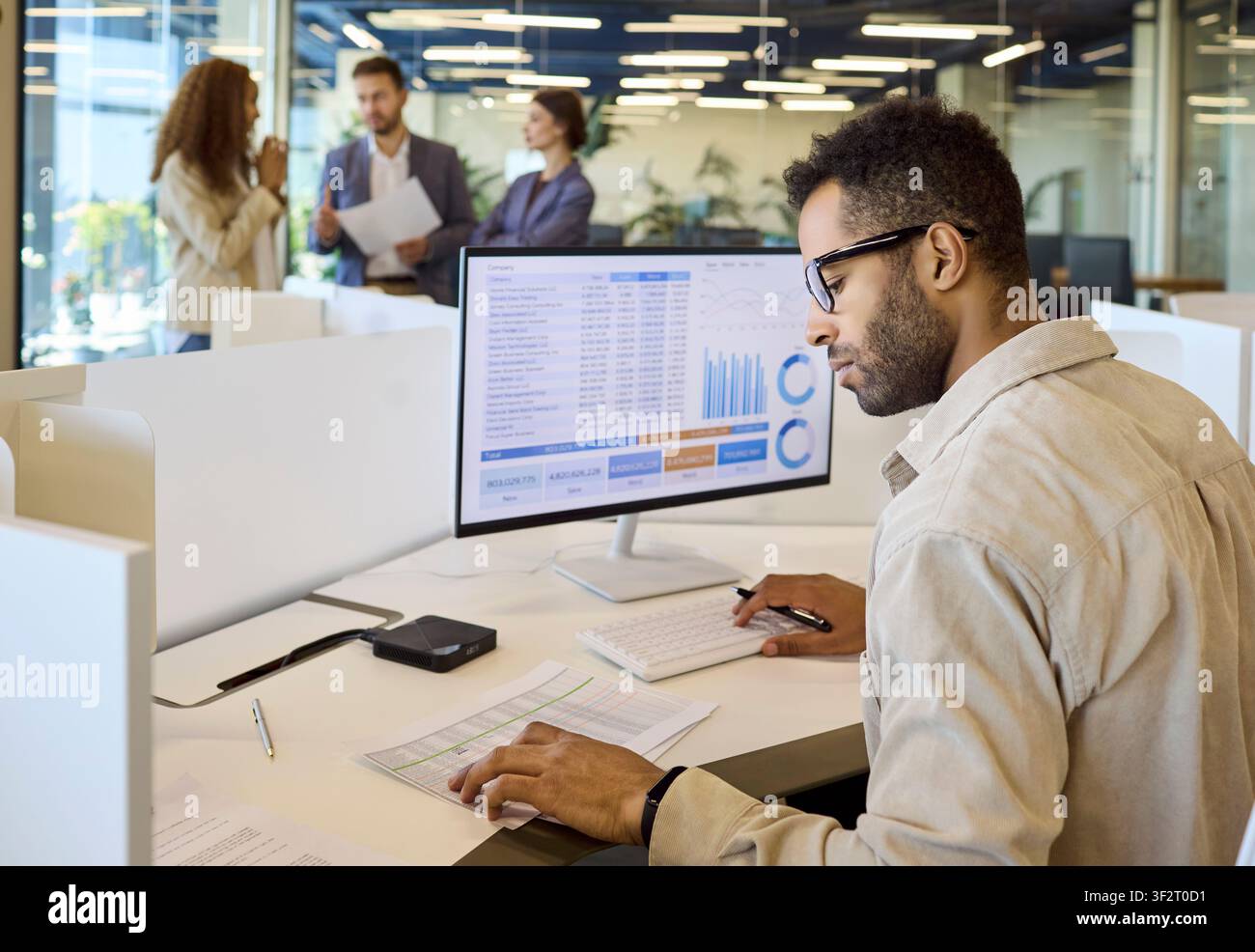 Financial manager analyzing spreadsheet charts on desktop computer in office Stock Photo
