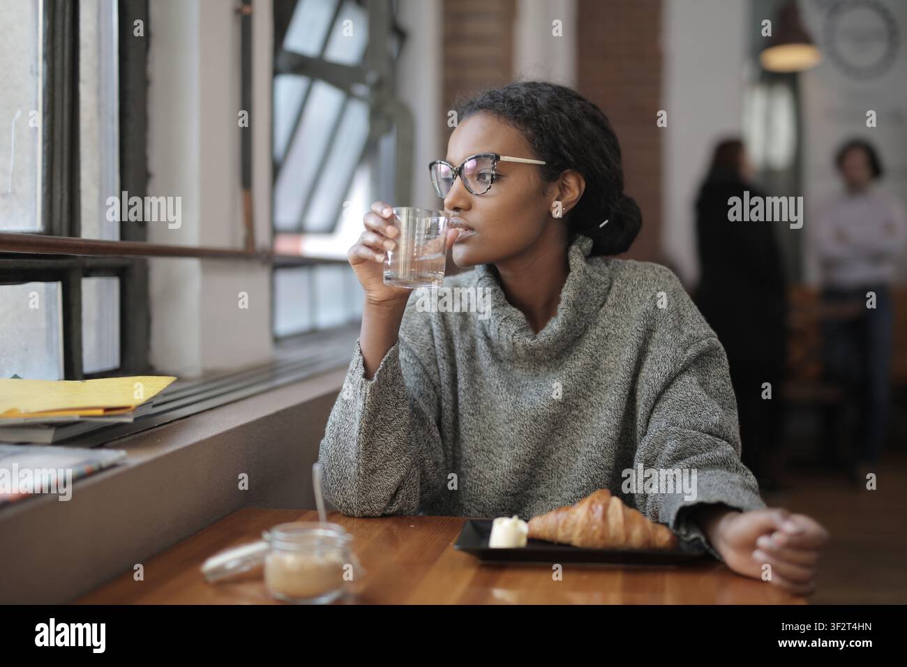 Thoughtful woman sitting alone in a coffee shop Stock Photo