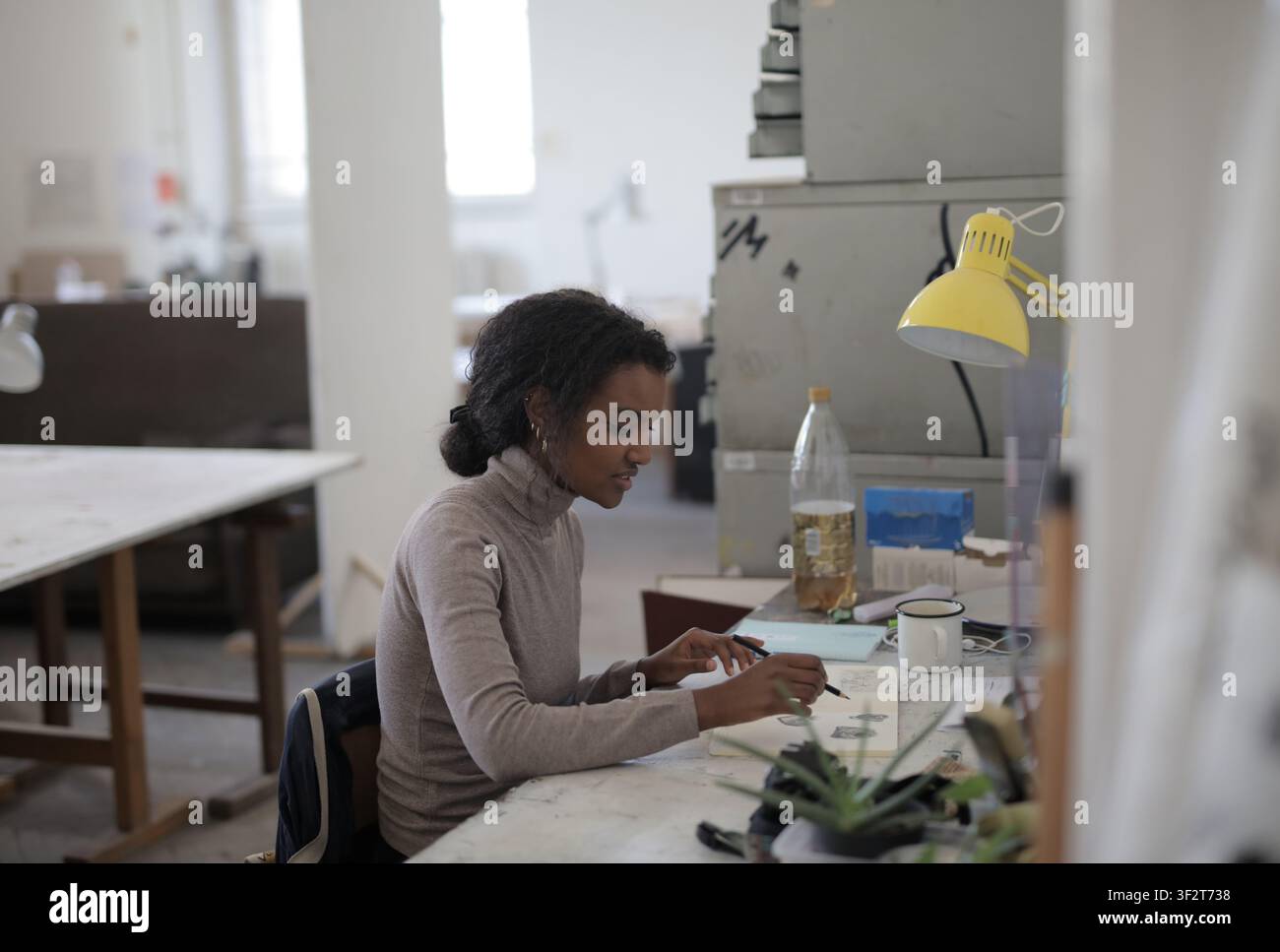 Young Black artist sketching in a creative studio Stock Photo