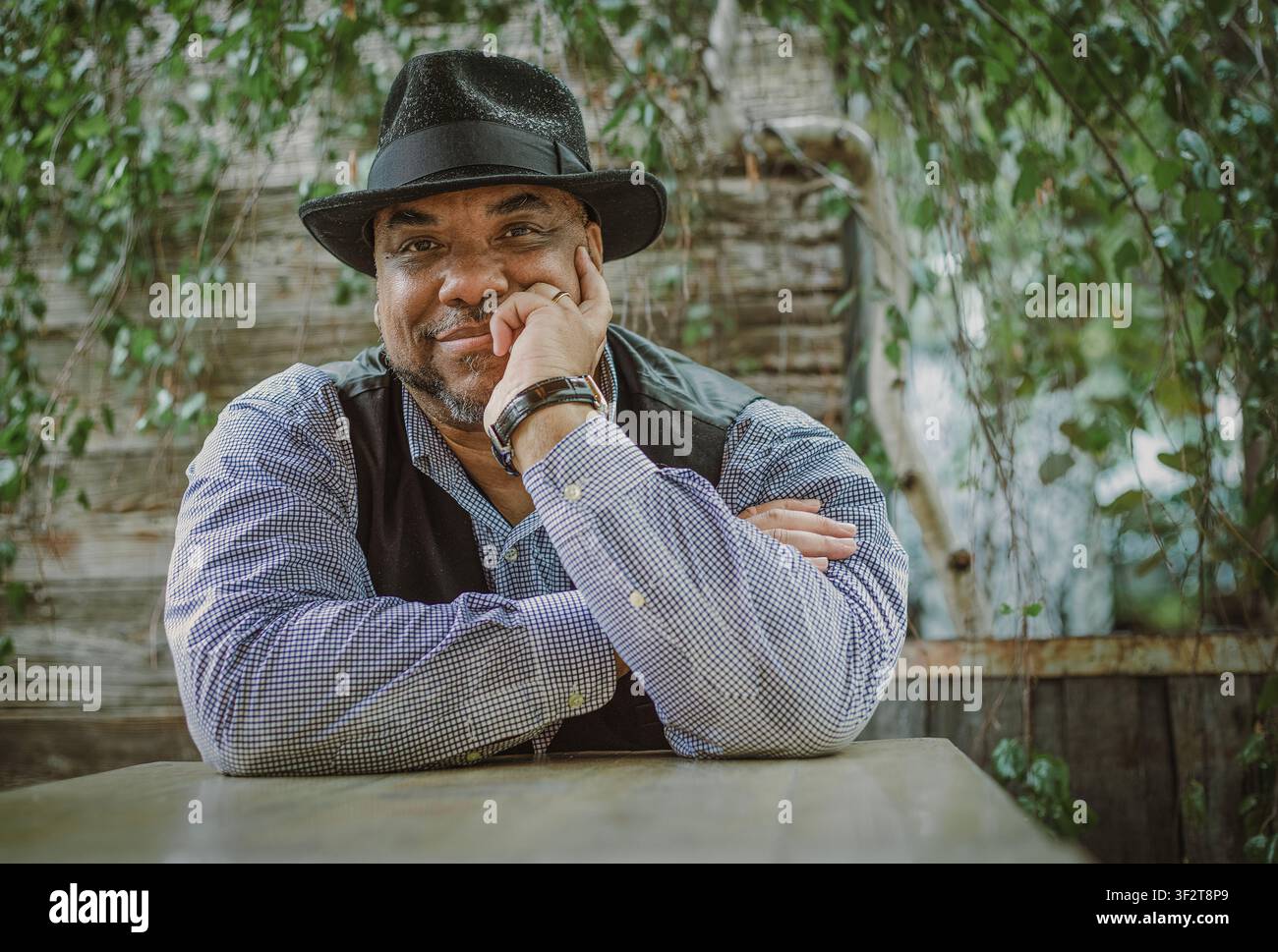 Confident Black man in fedora hat smiling outdoors Stock Photo
