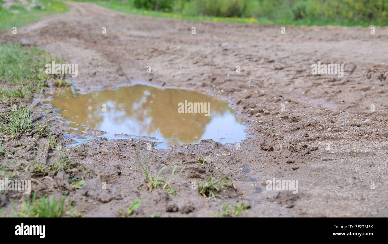 Muddy Road With Large Puddles After Rain Stock Photo
