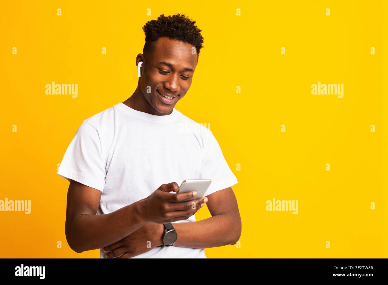 Smiling african young man in holding cellphone Stock Photo