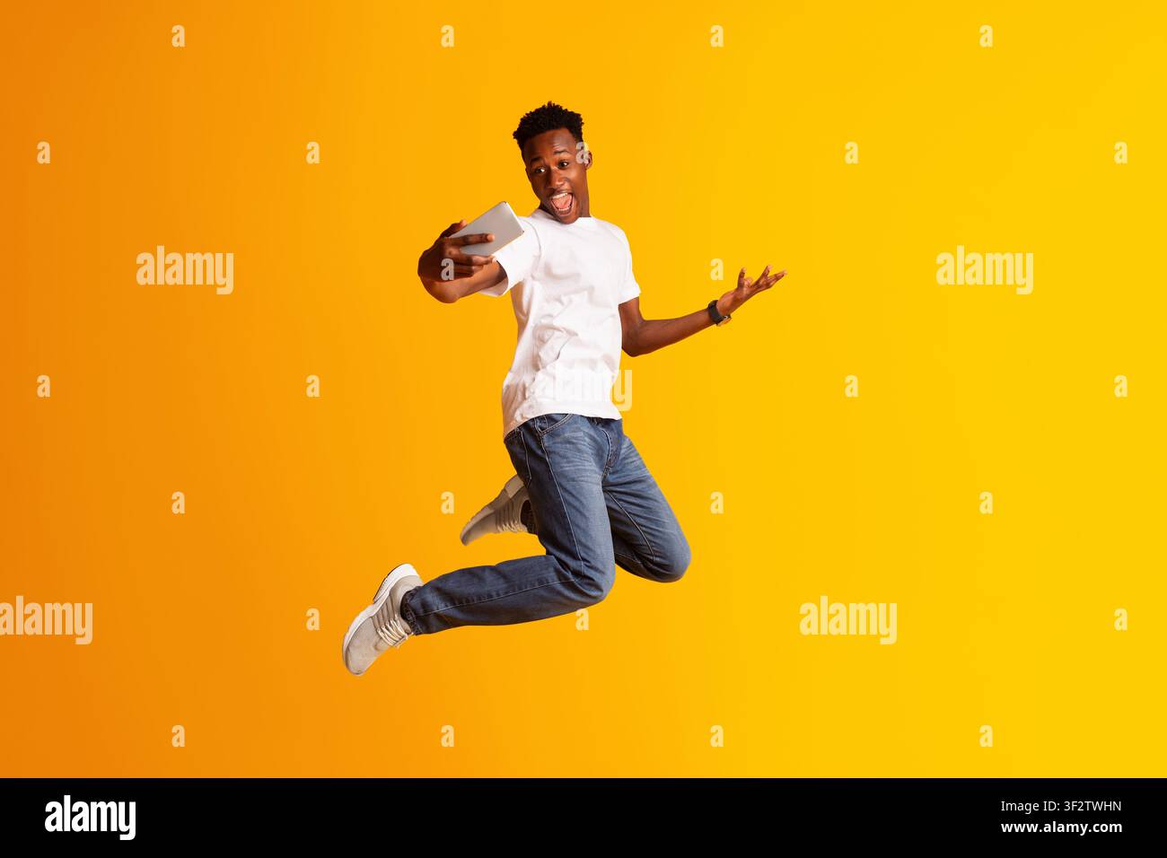 Handsome african guy making selfie while jumping Stock Photo