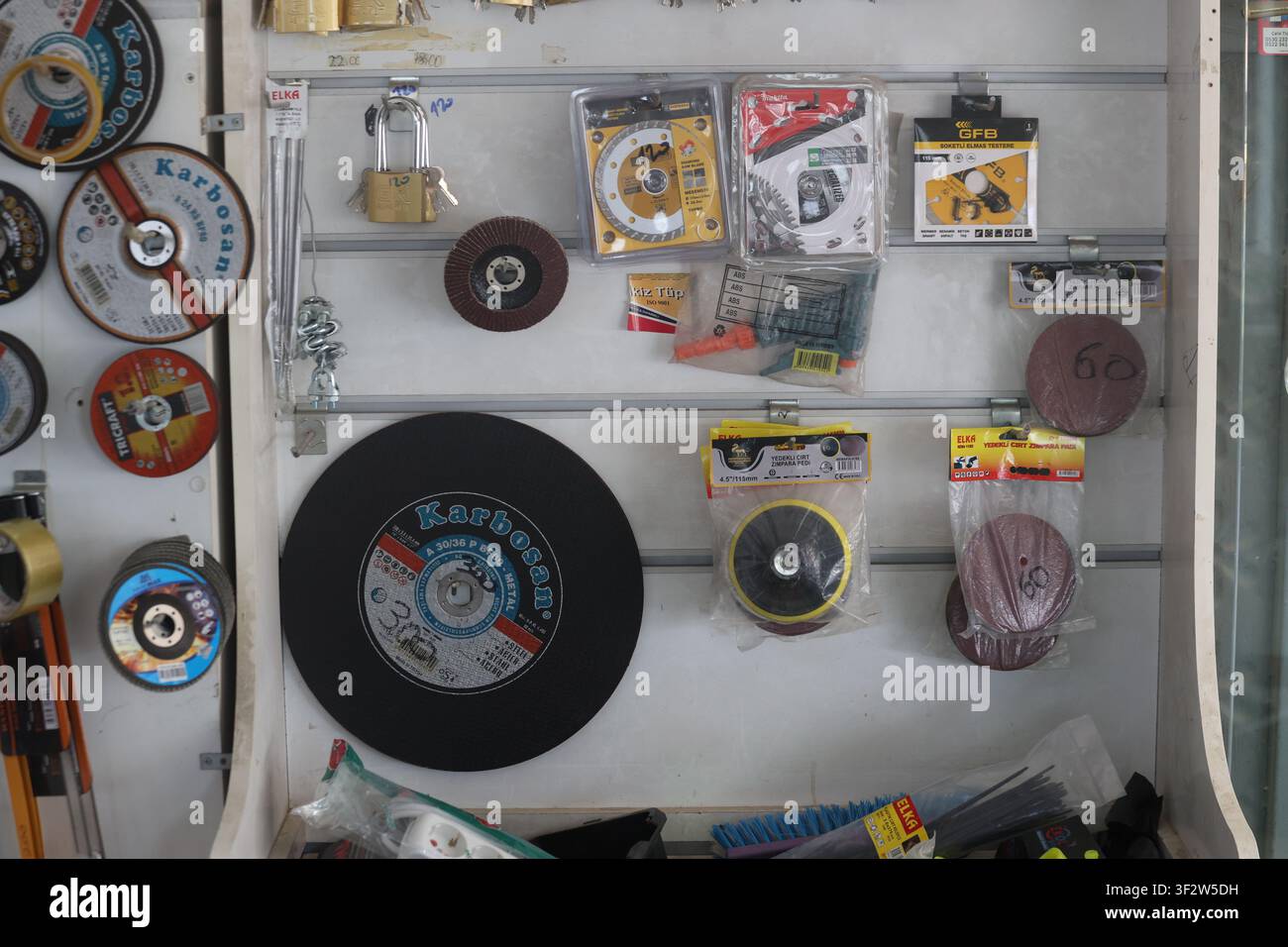 Assorted grinding discs, cutting wheels, and abrasive tools displayed on a hardware store retail rack Stock Photo