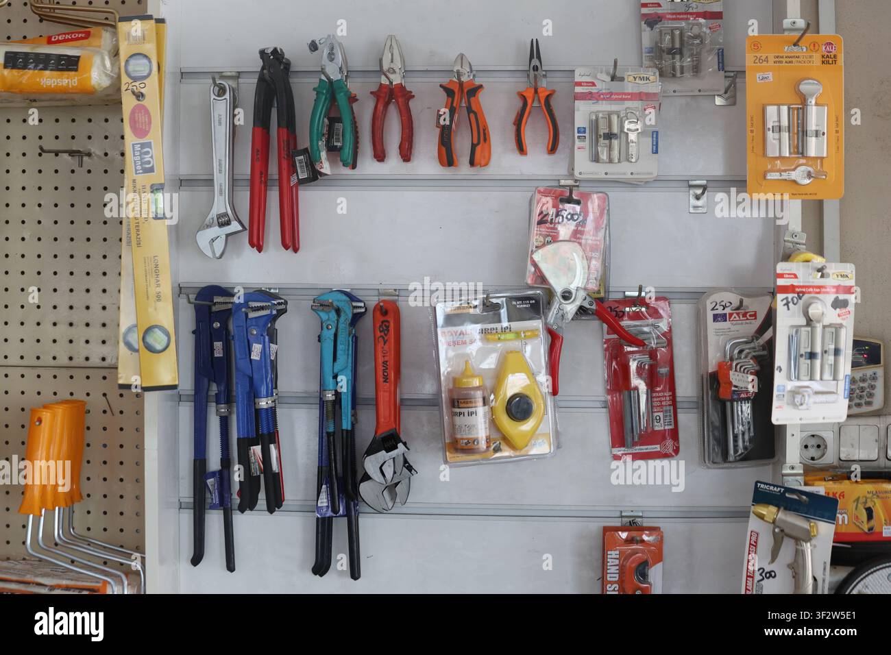 Various construction and hand tools displayed on a retail store wall organizer Stock Photo