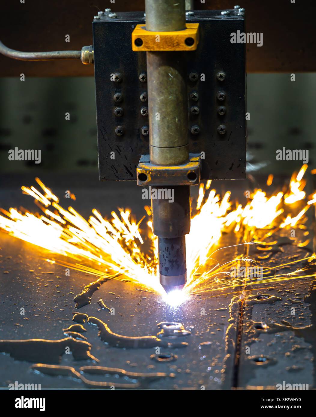 CNC laser cutting machine processing sheet metal with bright sparks Stock Photo