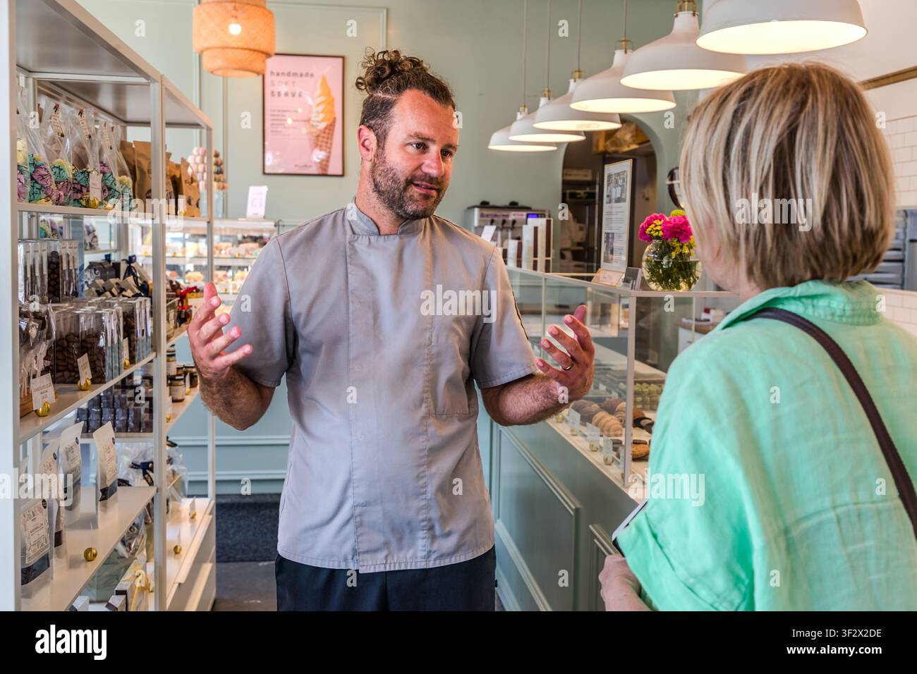 Chocolatier Julian Rousseau in conversation with journalist Angela Berg. The confectionery produces its pralines and chocolate creations by hand. The confectioner’s makes its pralines and chocolate creations by hand. Halifax, Nova Scotia, Canada Stock Photo