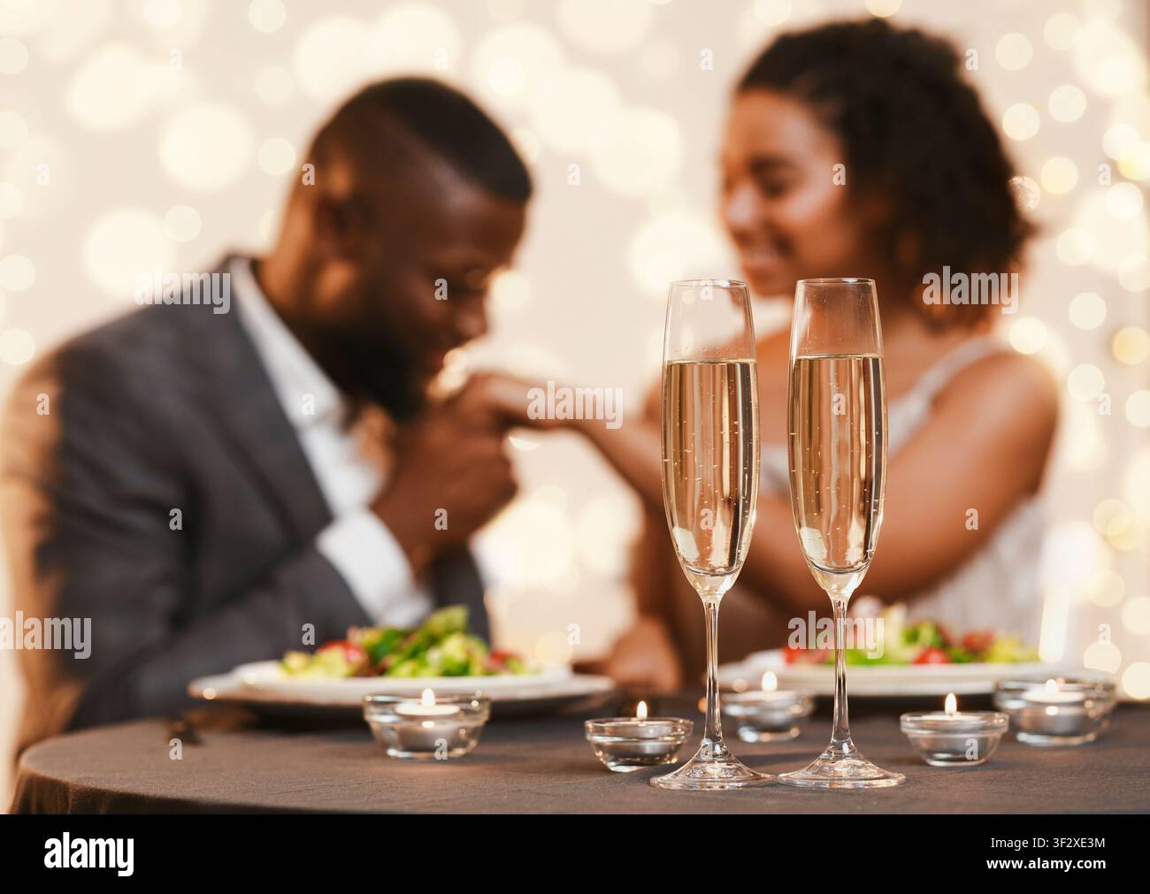 Black man and woman having romantic date at restaurant Stock Photo