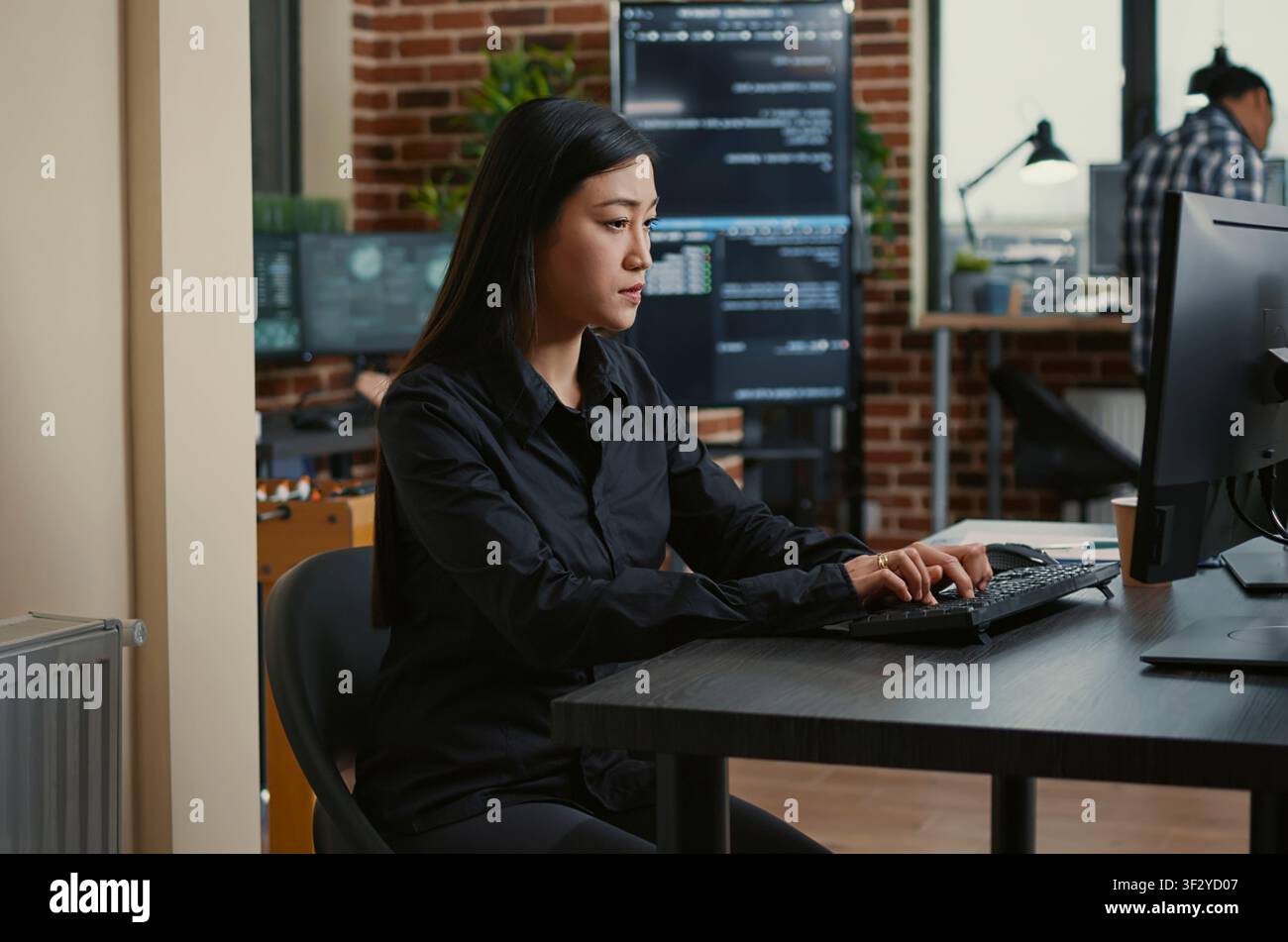 Software developers collaborate at the desk while reviewing source code, discussing algorithms and working together on a cloud computing project. Stock Photo