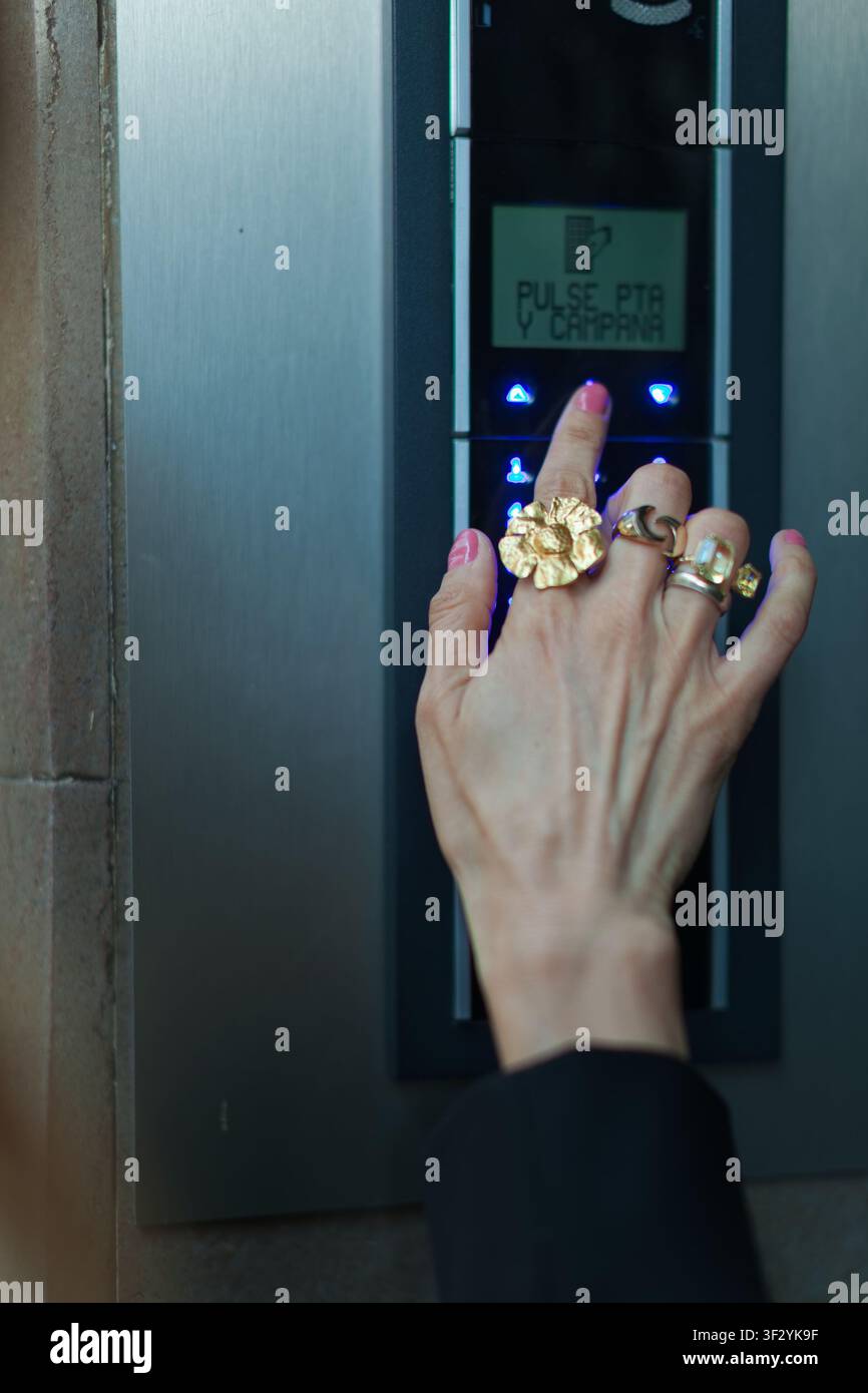 Hand pressing button on modern intercom Stock Photo