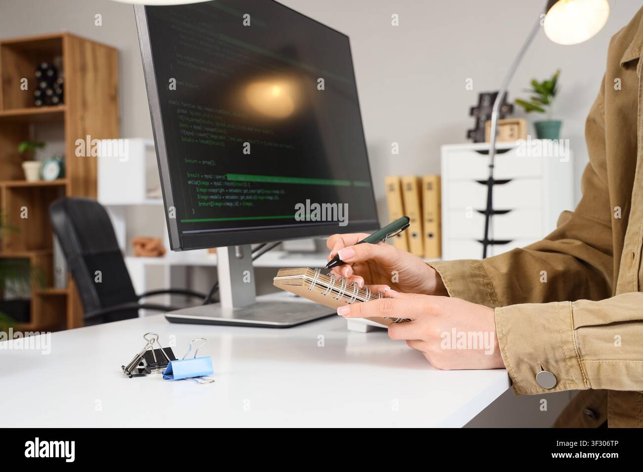 Female programmers hands writing in notebook at office Stock Photo