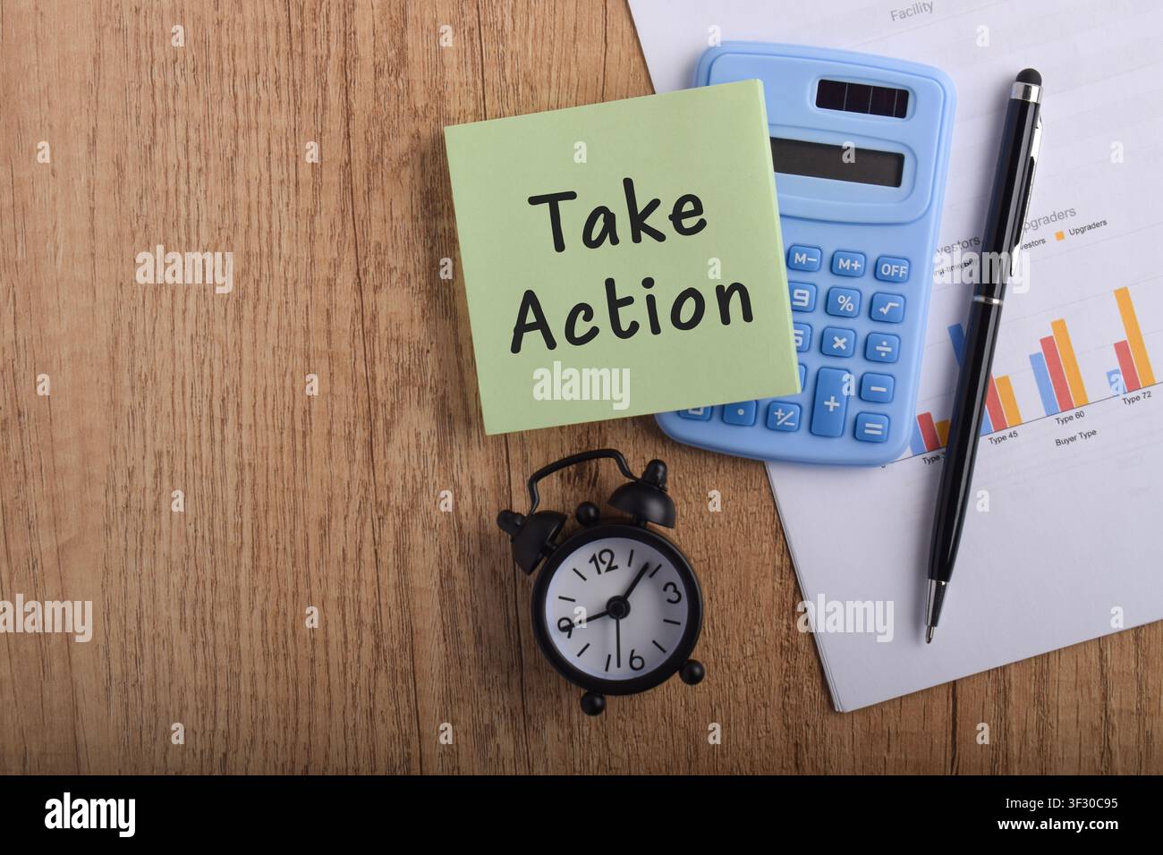 Take action concept with sticky note, calculator, alarm clock, and financial report on desk, symbolizing productivity, decision making, business plann Stock Photo