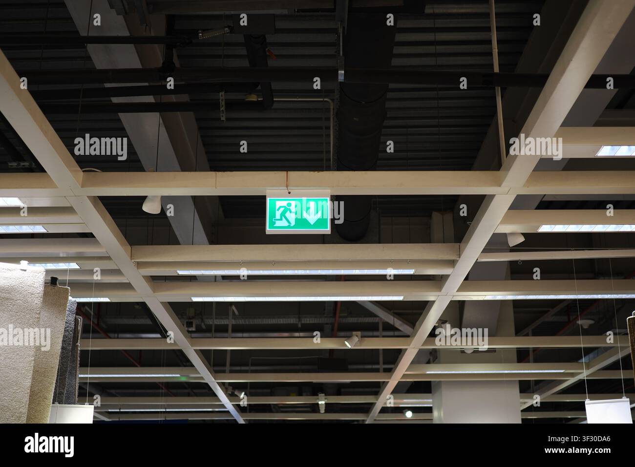 Exit sign is visible on the ceiling in a store Stock Photo