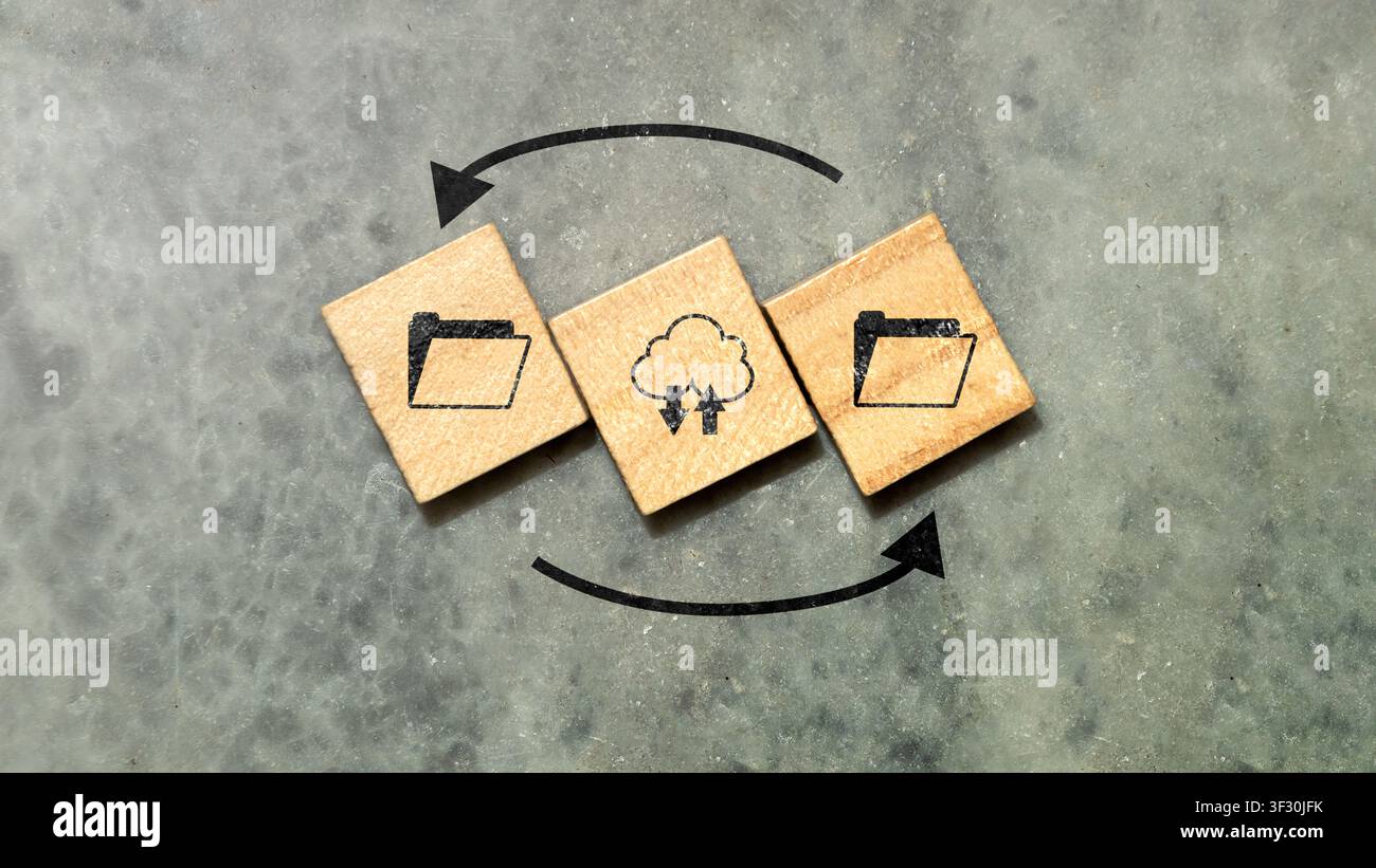 Conceptual image representing cloud computing, data backup, and file synchronization using wooden blocks with icons on a concrete background. Ideal fo Stock Photo