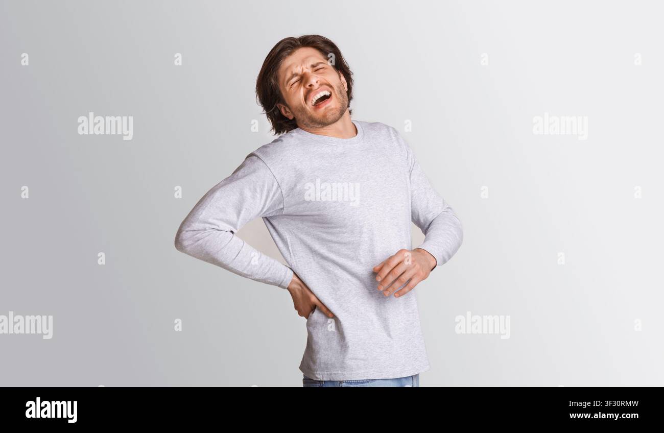 Sharp back pain. Man suffering from pain and screams Stock Photo