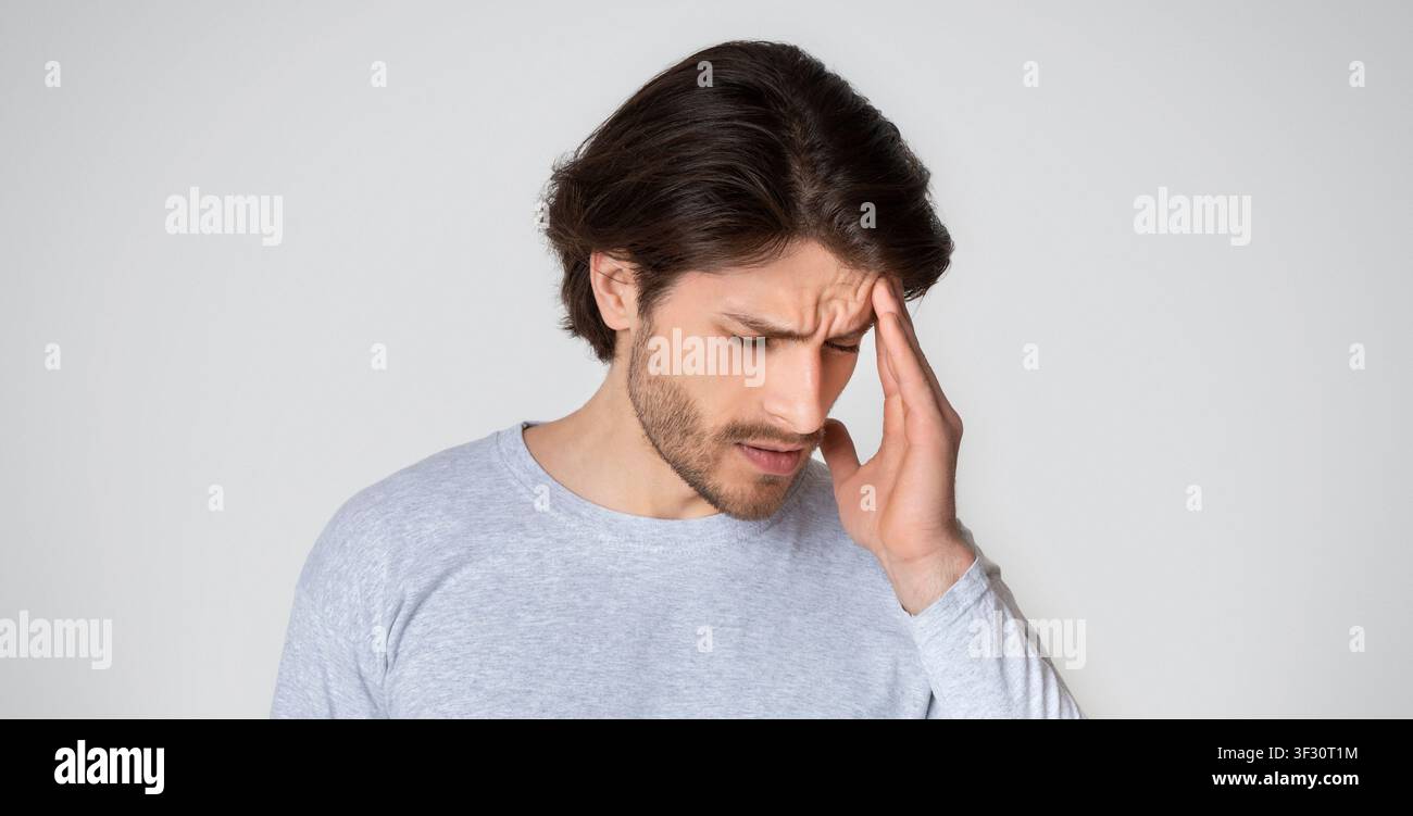 Sick man suffering from headache at home Stock Photo