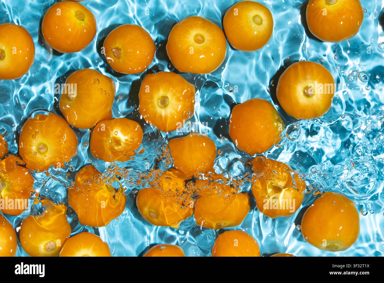 Fresh physalis berries washing in clean water with splashes Stock Photo