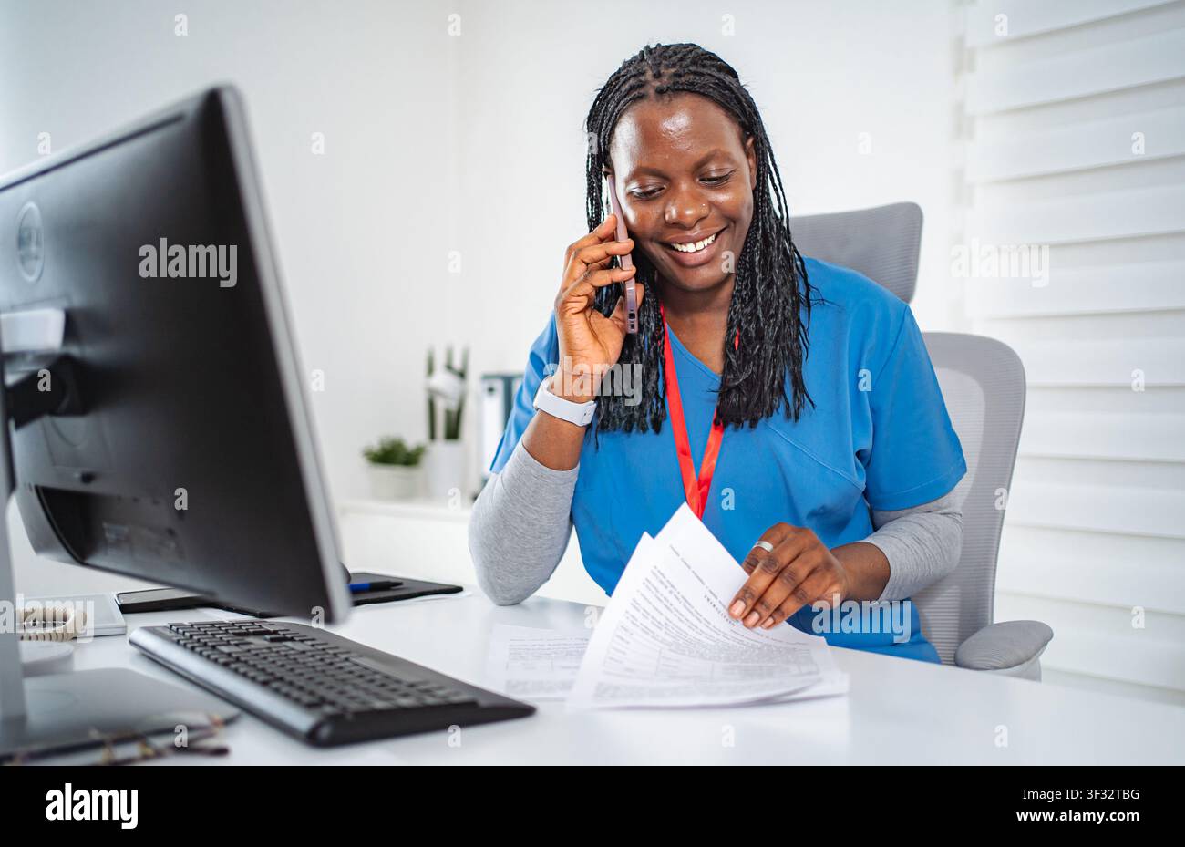Female nurse communicating on phone while working in office Stock Photo