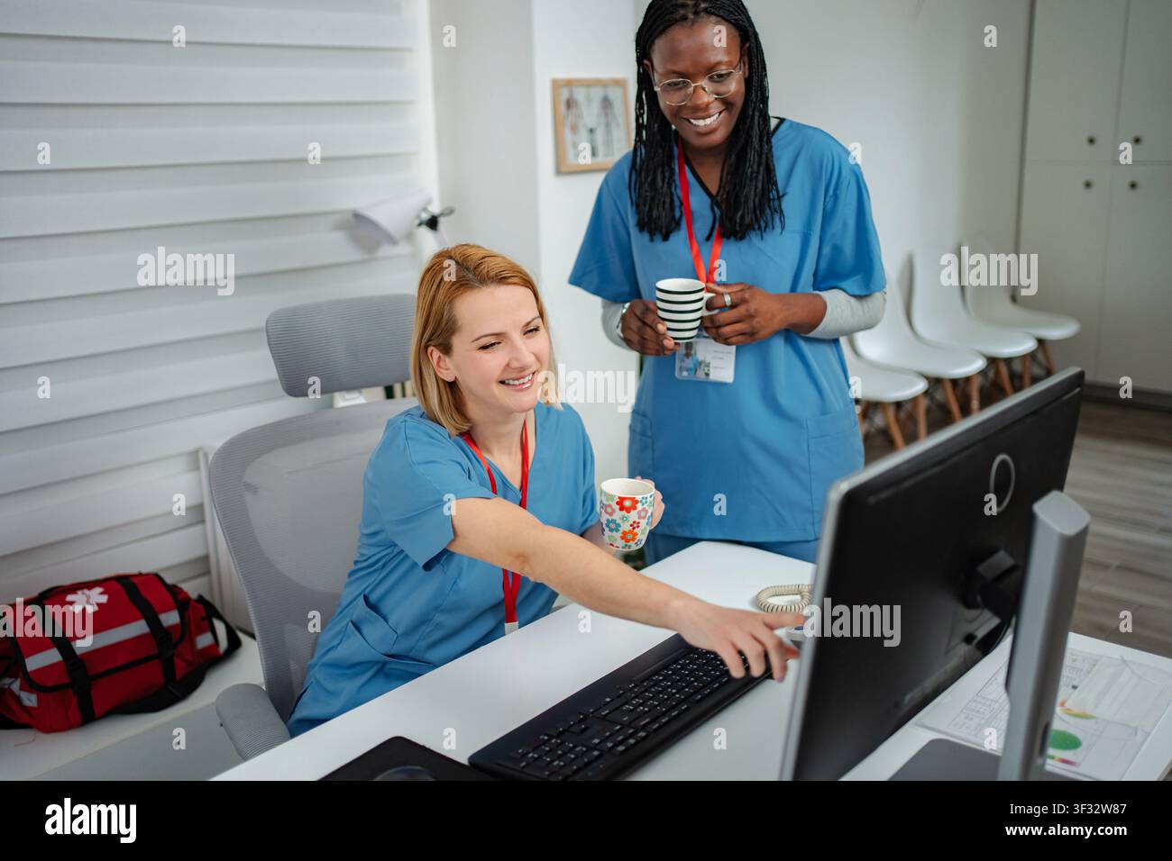 Medical team collaborating on computer during coffee break Stock Photo