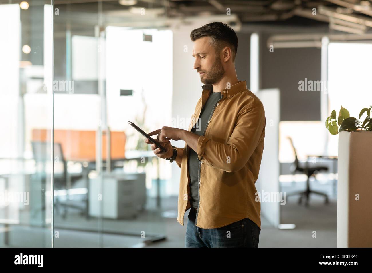 Man Using Tablet In Office, Focused On Digital Device, Business Concept Stock Photo