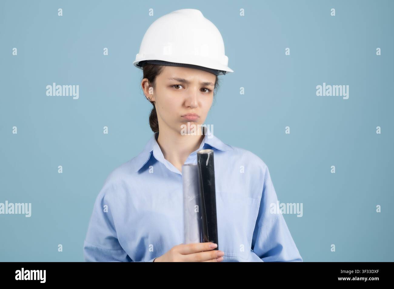 Thoughtful woman engineer holding building blueprint rolled documents Stock Photo