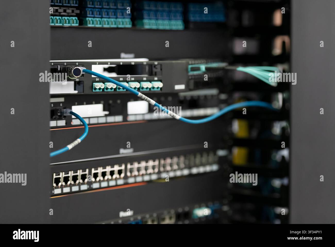 Network Server Rack with Patch Panels and Fiber Optic Cabling in Data Center Stock Photo