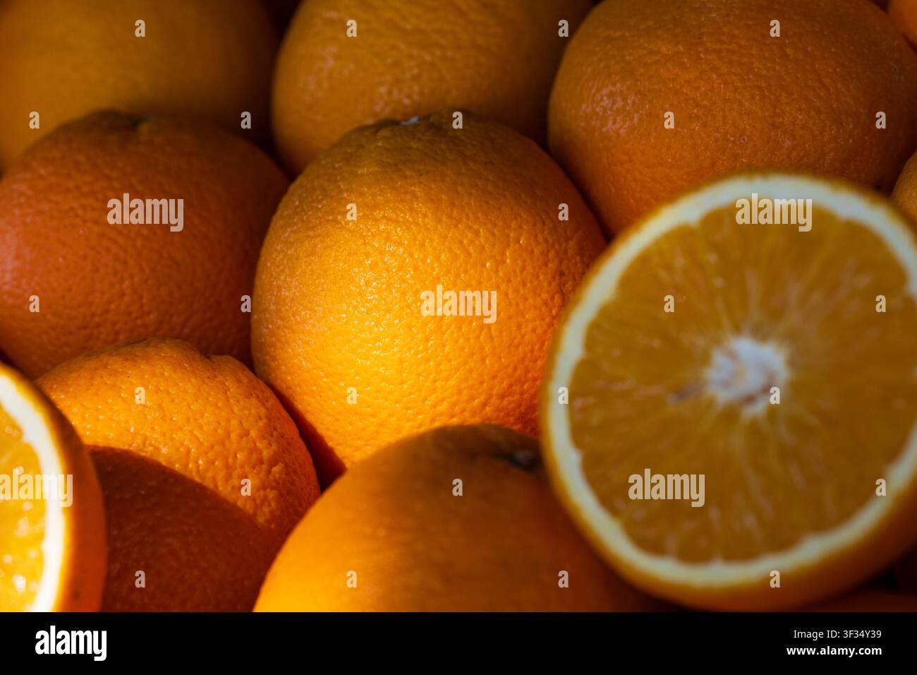Whole and sliced oranges showing fresh fruit textures and bright colors Stock Photo