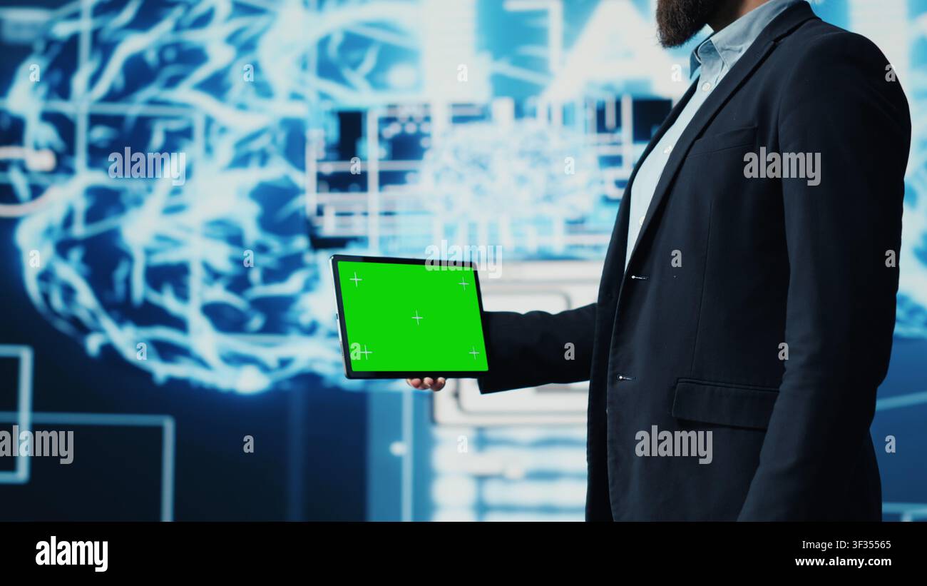 Studying neural networks systems, young IT specialist implements artificial intelligence with mockup screen on tablet. Man using automation for modern AI strategy and innovation. Camera A. Stock Photo