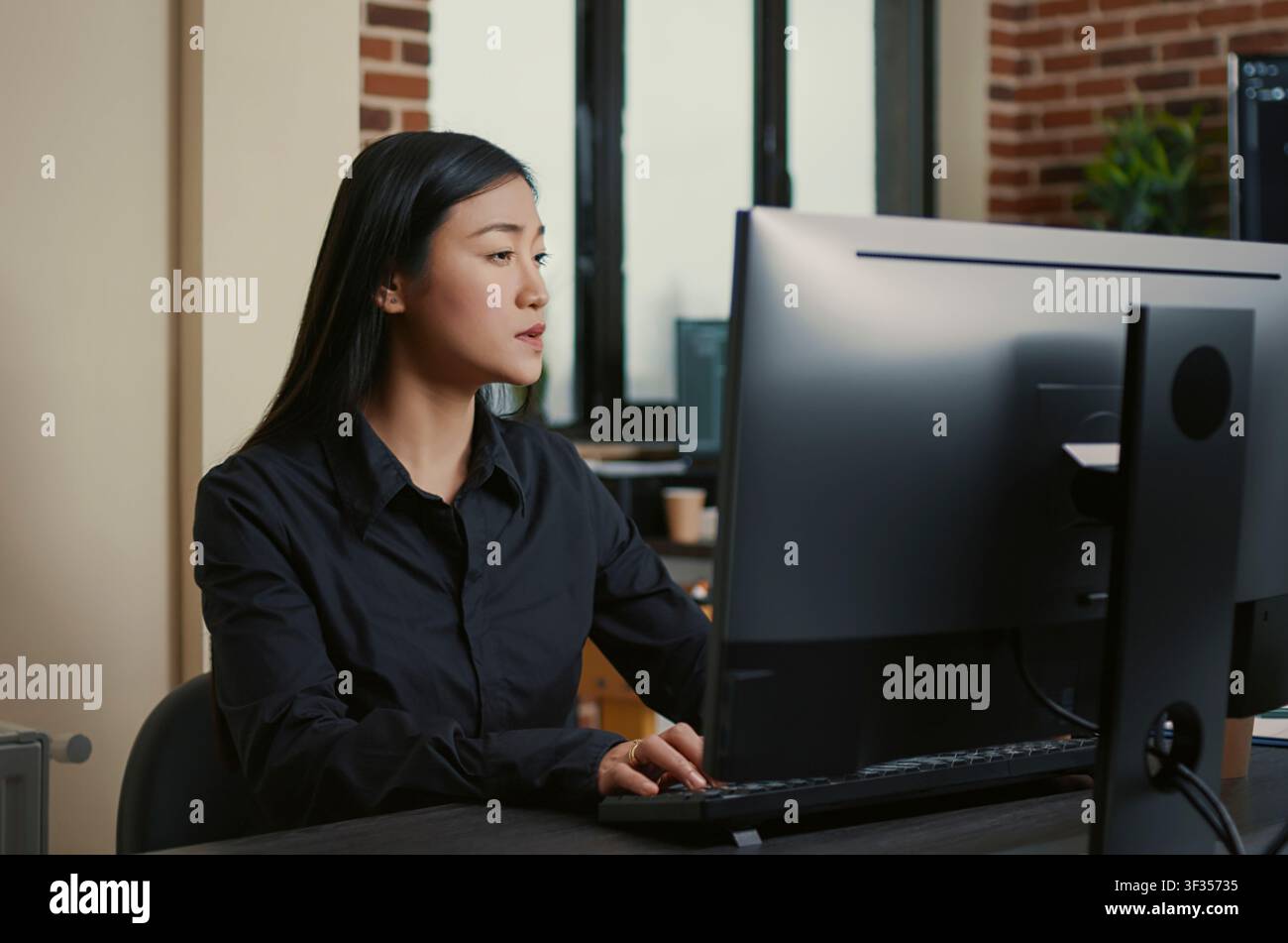 Programmer writes software code at an office desk, using computer screens, algorithms and database tools for digital application development. Stock Photo