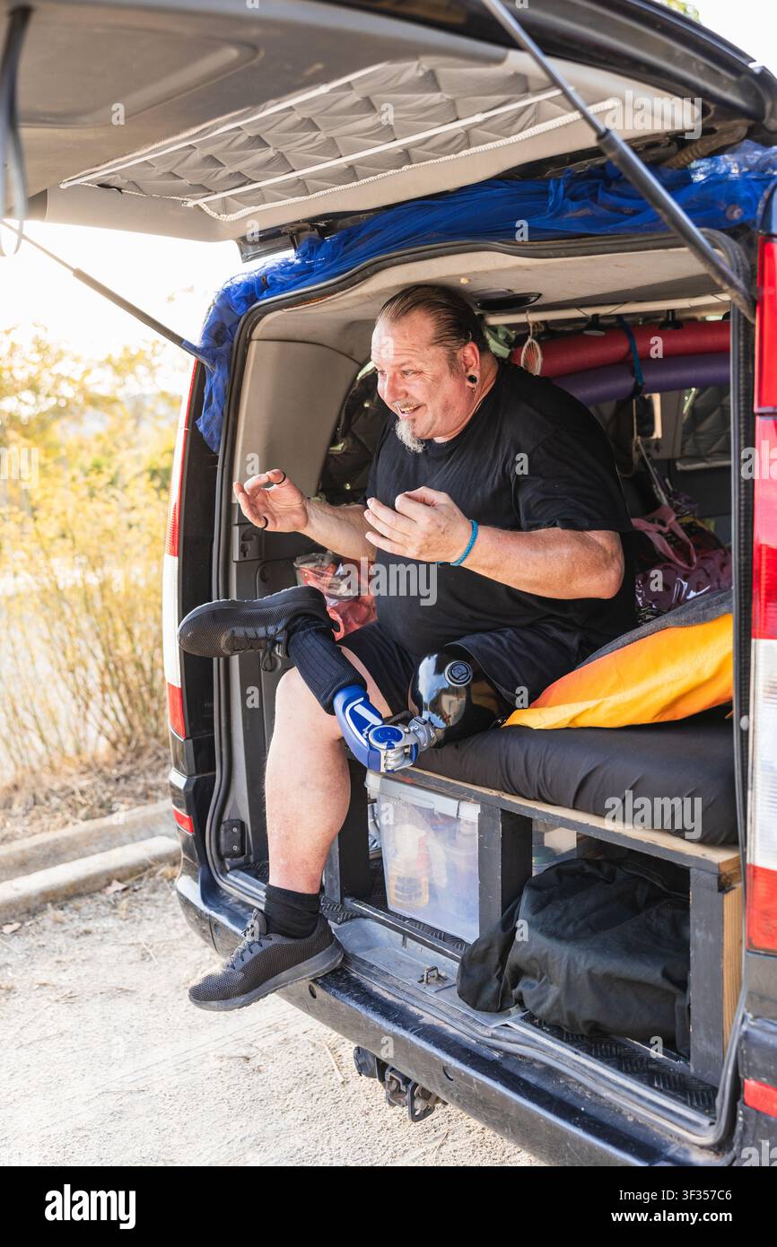 Man with prosthetic leg enjoying van life travel Stock Photo