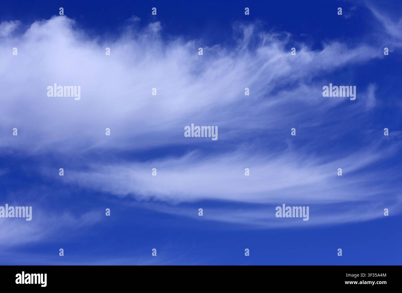 Cloudscape. Concepts - environment. Cirrus and cirrostratus clouds with a deep blue sky. Backgrounds. Copy space. Stock Photo