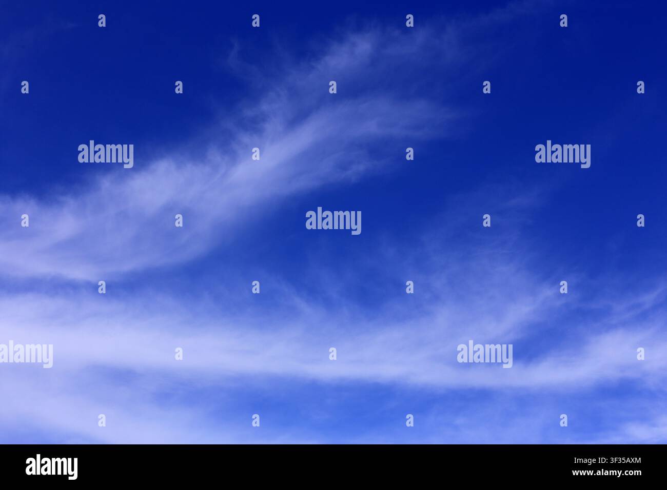 Cloudscape. Concepts - environment. Cirrus and cirrostratus clouds with a deep blue sky. Backgrounds. Copy space. Stock Photo