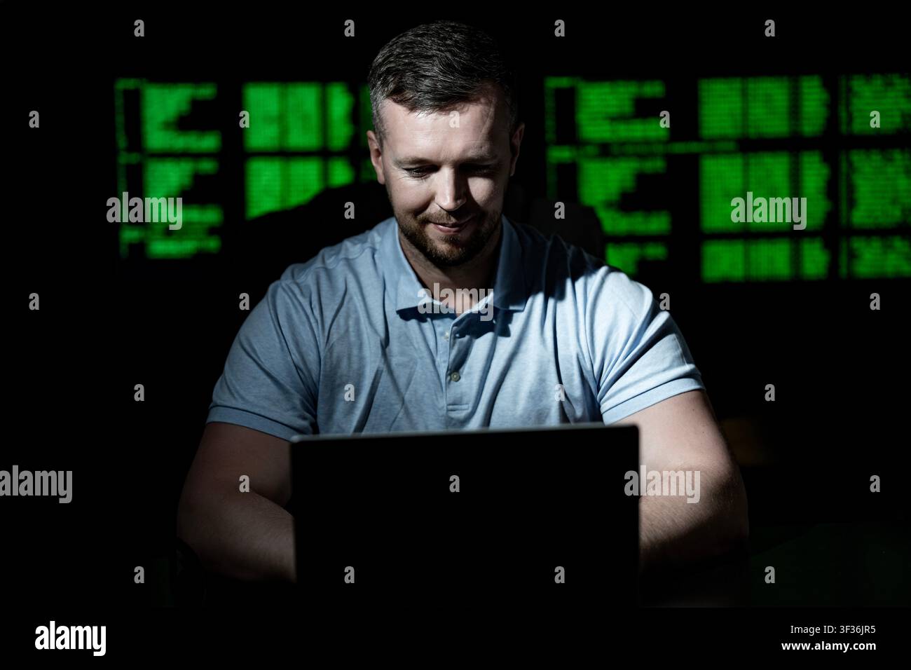 Programmer uses laptop for coding work. Programmer analyzes code screen with concentration. Programmer monitors network and firewall system Stock Photo
