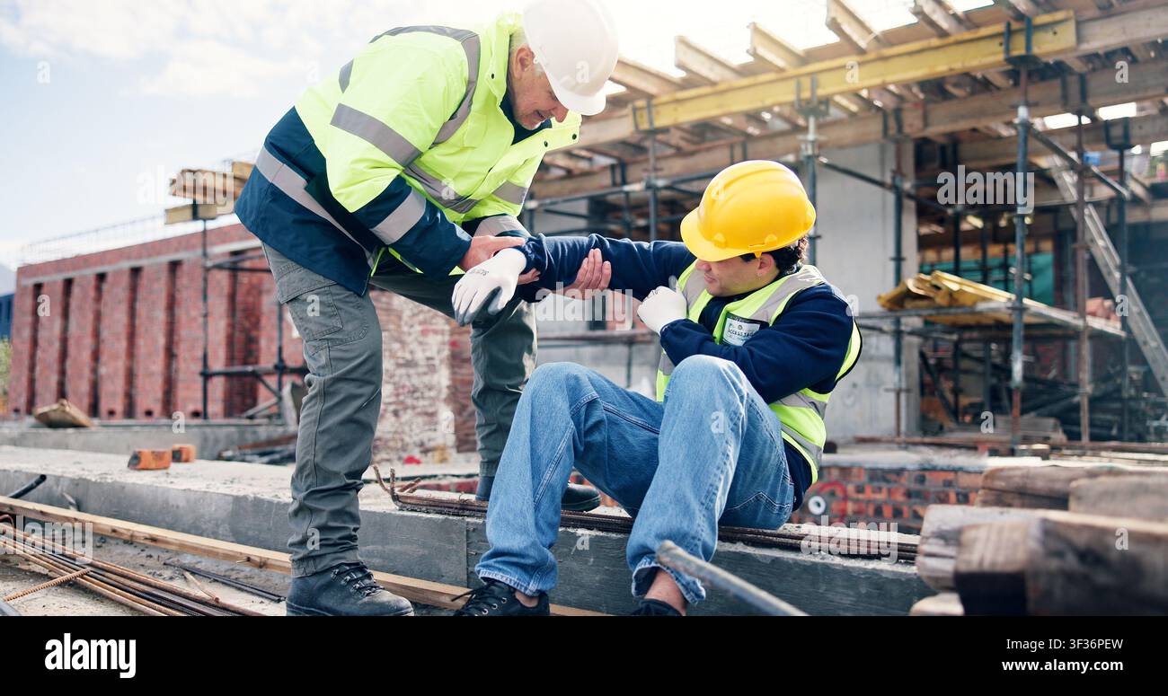 Construction, men and help with arm injury for scaffolding accident, building hazard or fracture. Site first aid, workers and assistance for muscle Stock Photo