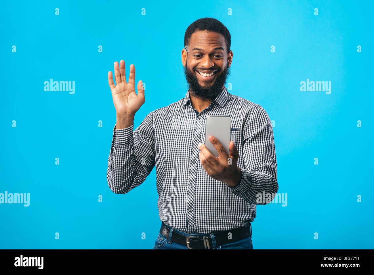 Happy black man using mobile phone at studio Stock Photo