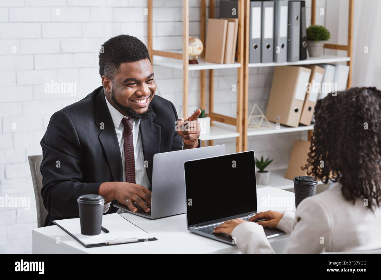 Teamwork and collaboration. Smiling colleagues having friendly communication at workplace Stock Photo