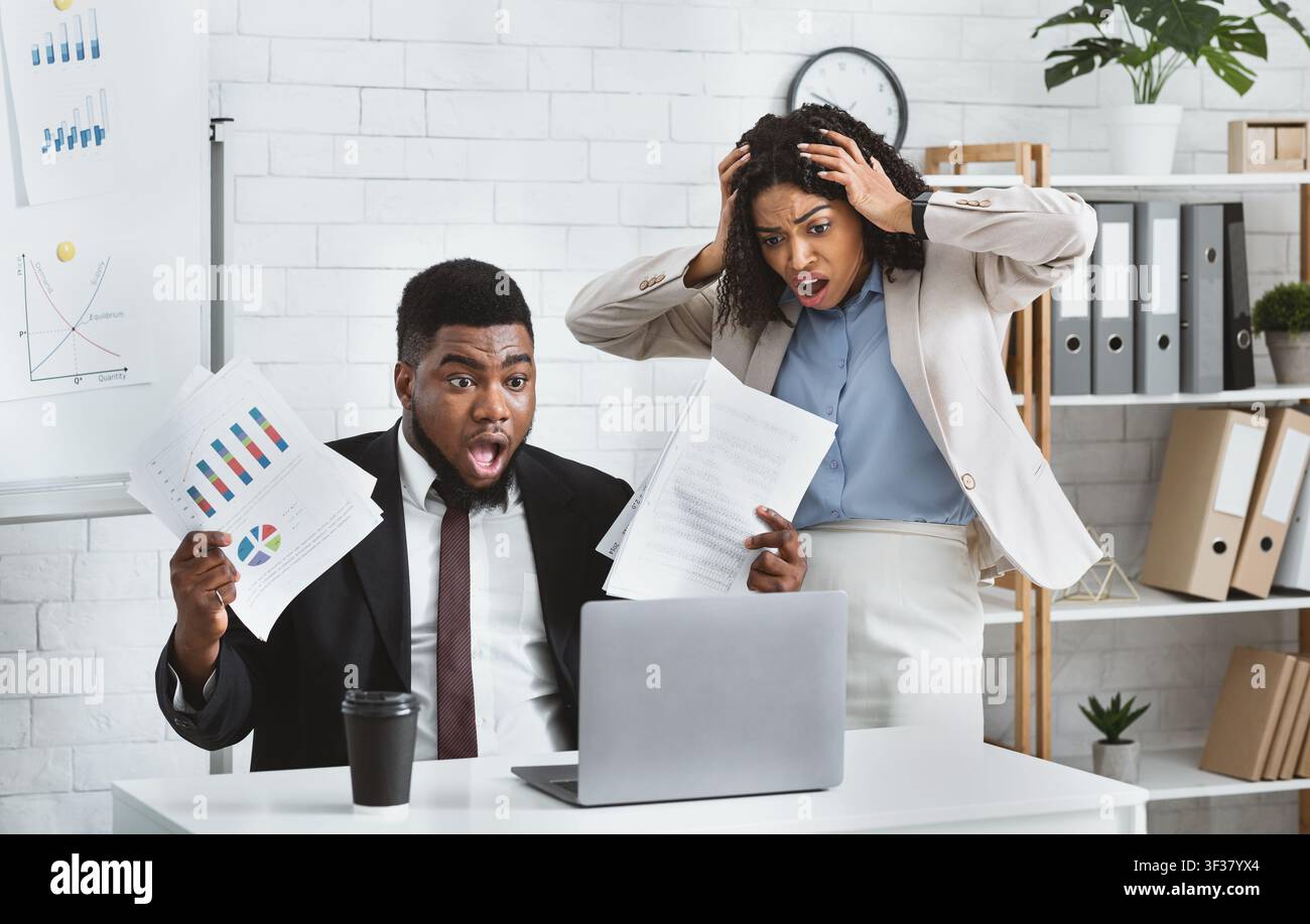 Stressed African American colleagues missing project deadline at office Stock Photo