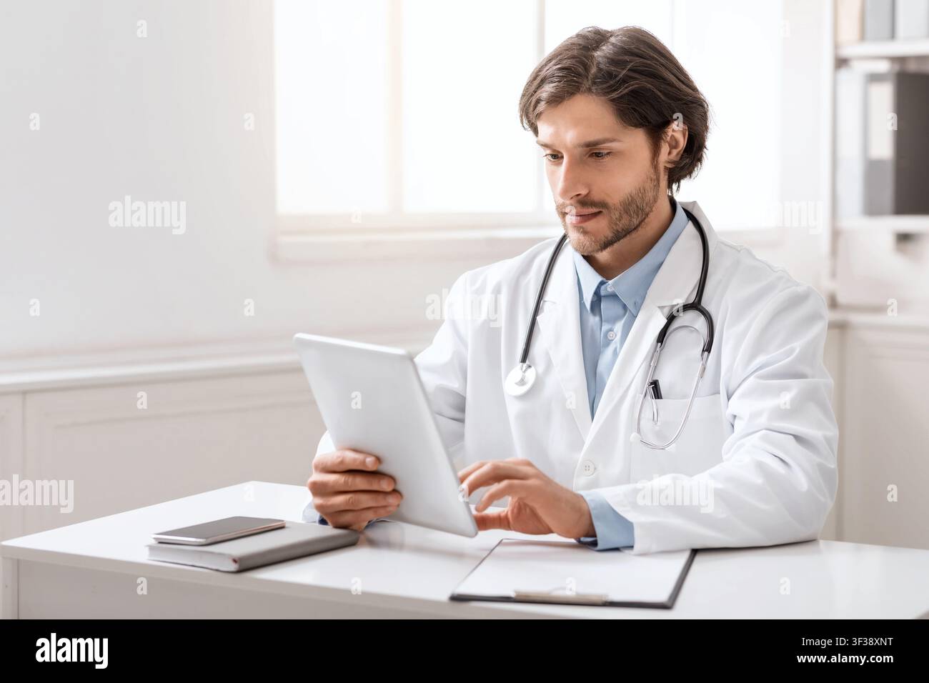 Young doctor using digital tablet for work in office Stock Photo