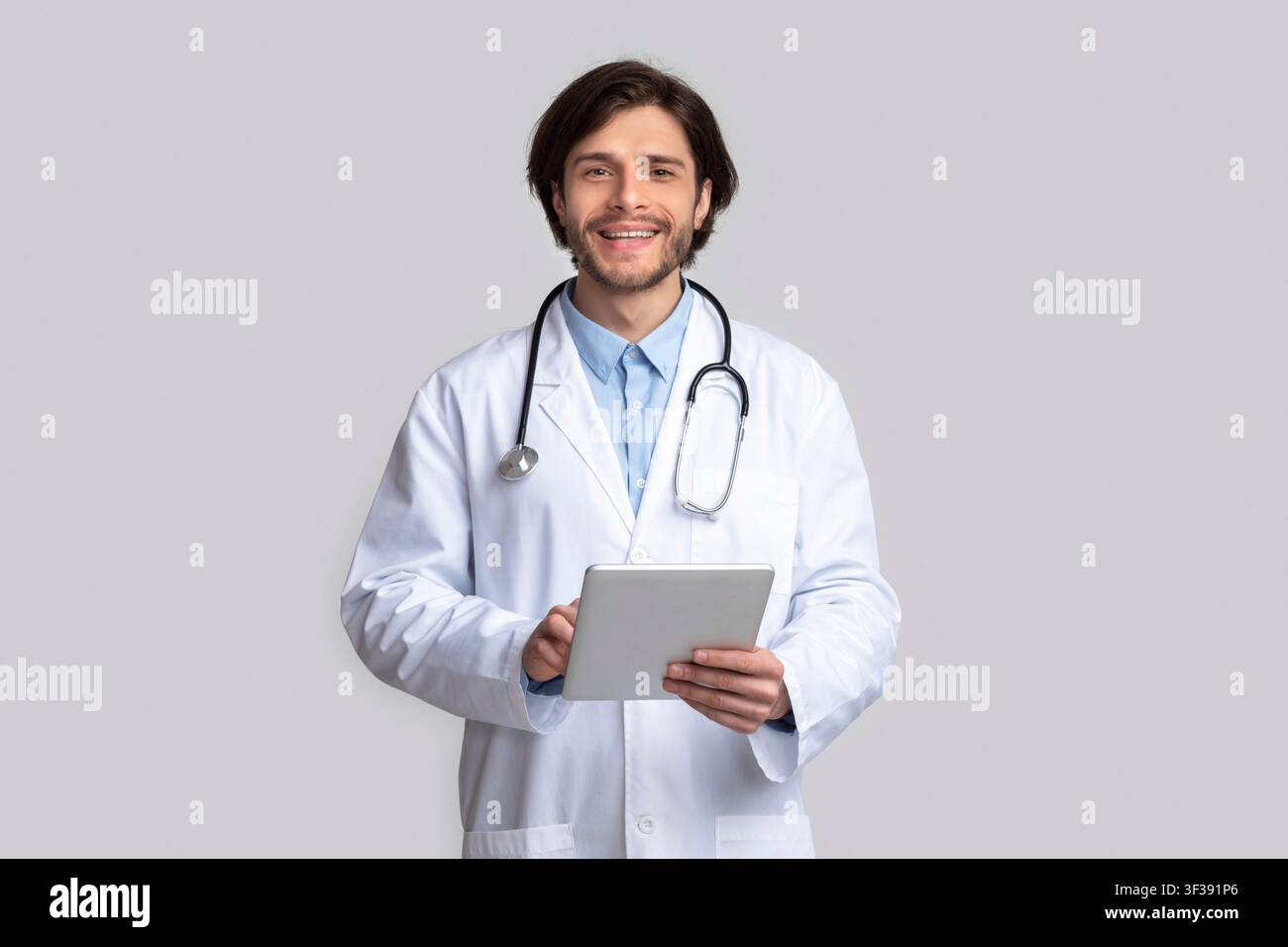 Cheerful doctor using digital tablet in hands Stock Photo