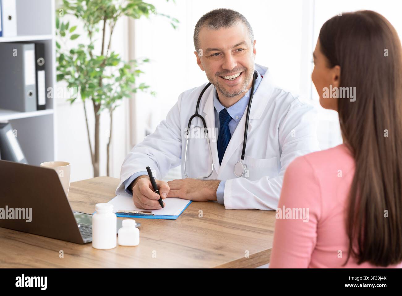 Male experienced doctor talking to his female patient Stock Photo