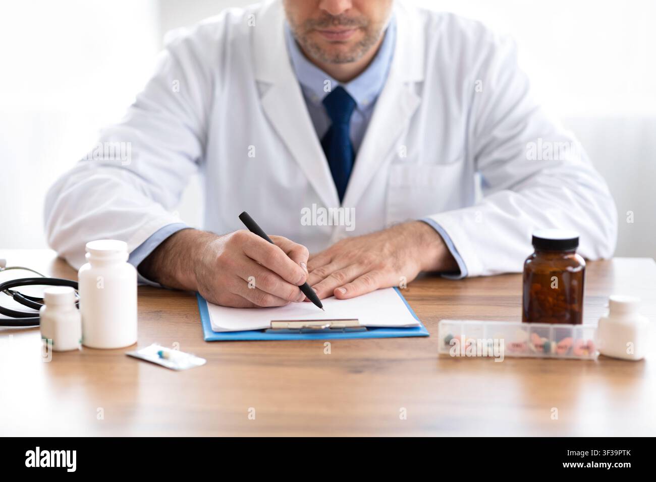 Close up of medical practitioner filling in paperwork Stock Photo