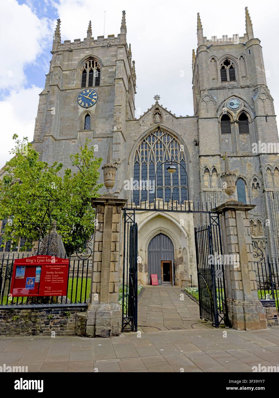 King's Lynn Minster, formerly St Margaret's Church, viewed through its west entrance gates beneath a bright summer sky in Norfolk, England Stock Photo