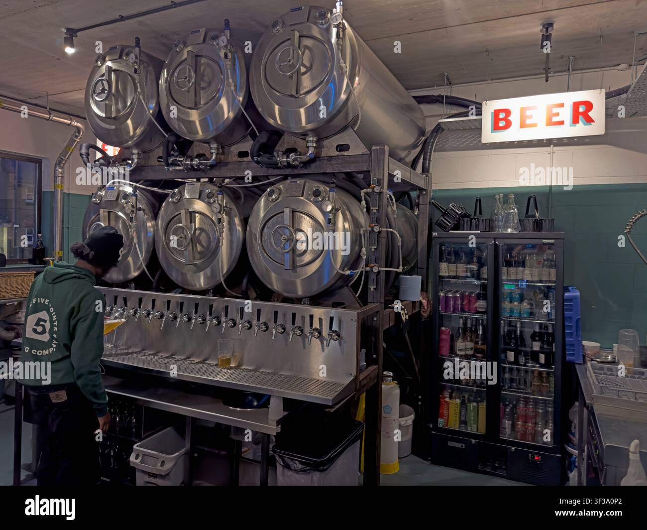 Staff member pouring tank-fresh craft beer at The Five Points Brewery taproom on Mare Street in Hackney, East London Stock Photo