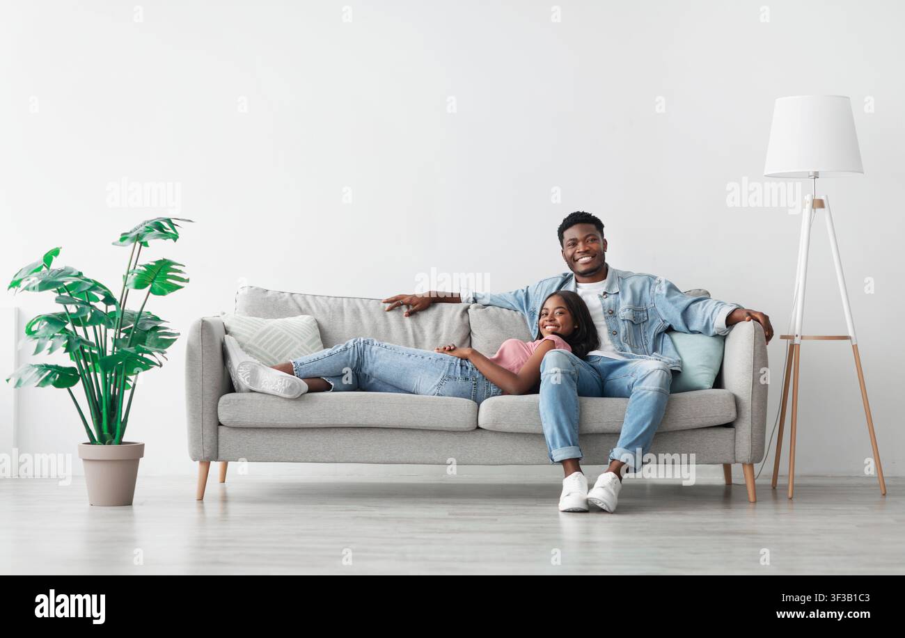 African american couple spending weekend together lying on couch Stock Photo