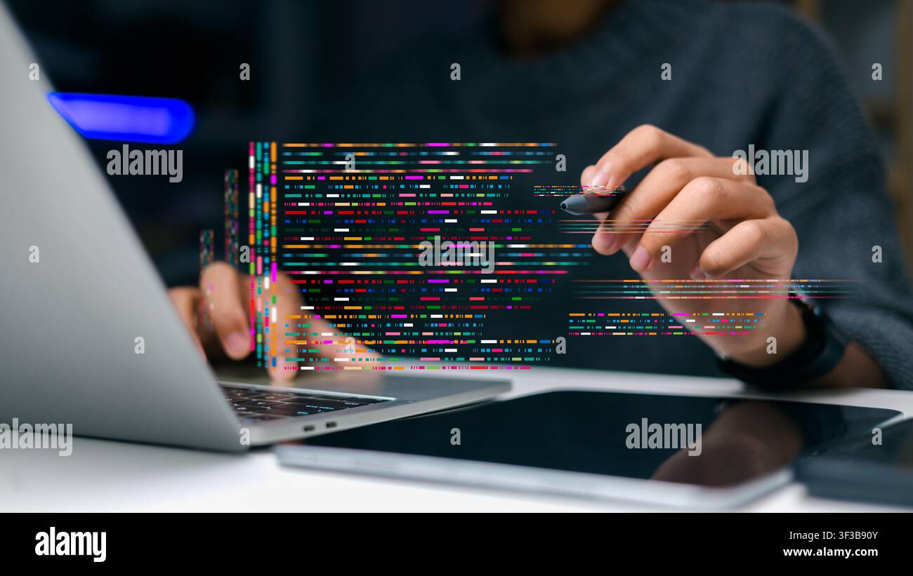 Close up programmer holding stylus pen pointing at colorful software coding script while working on laptop computer at office desk, digital applicatio Stock Photo