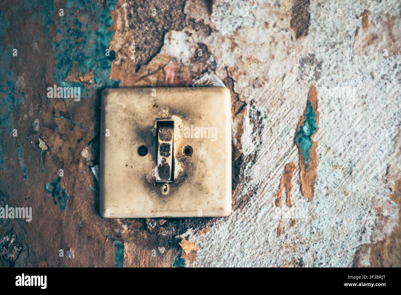 An old Soviet light switch on a peeling wall Stock Photo