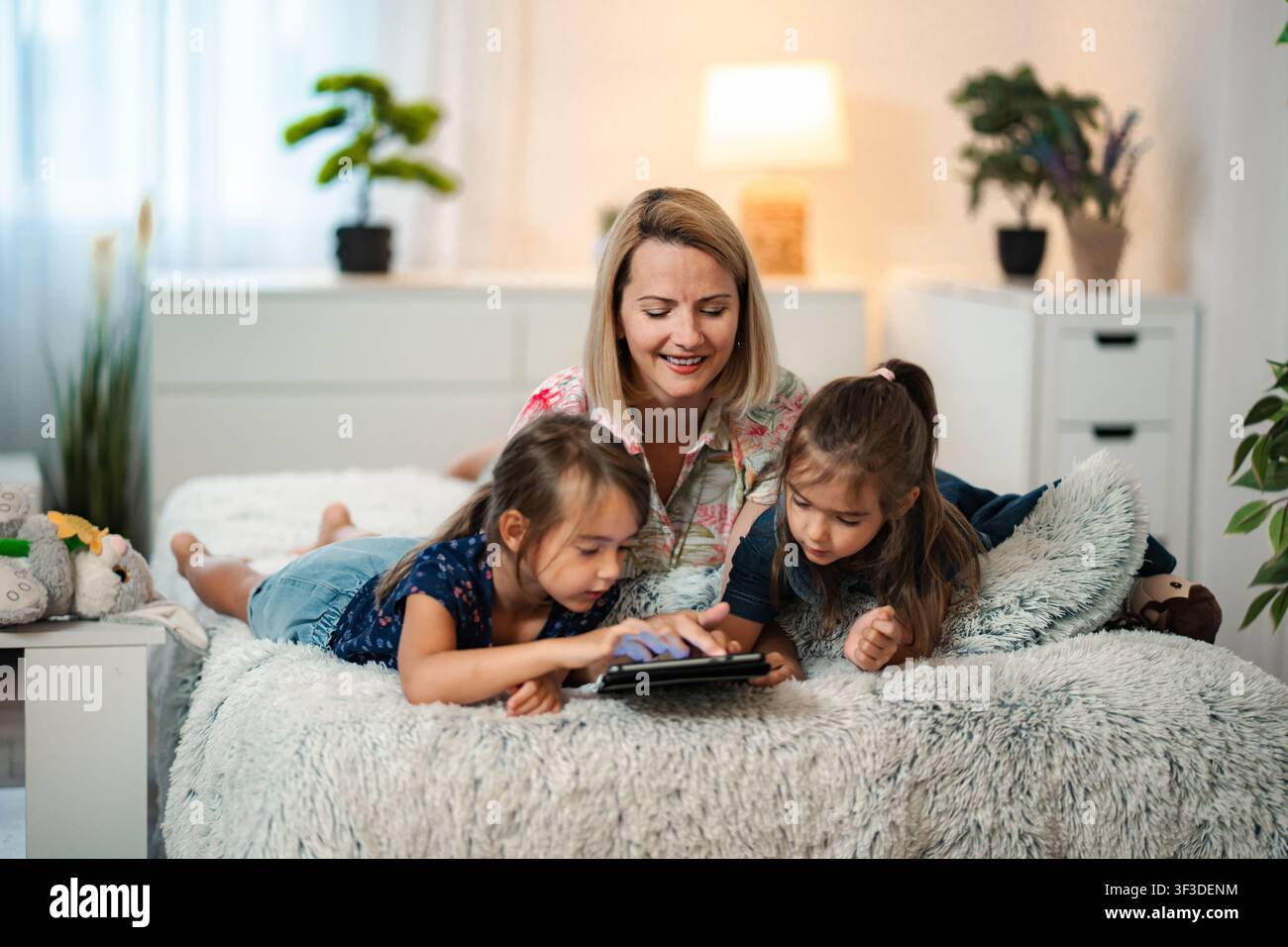Mother and daughters learning together using digital tablet Stock Photo