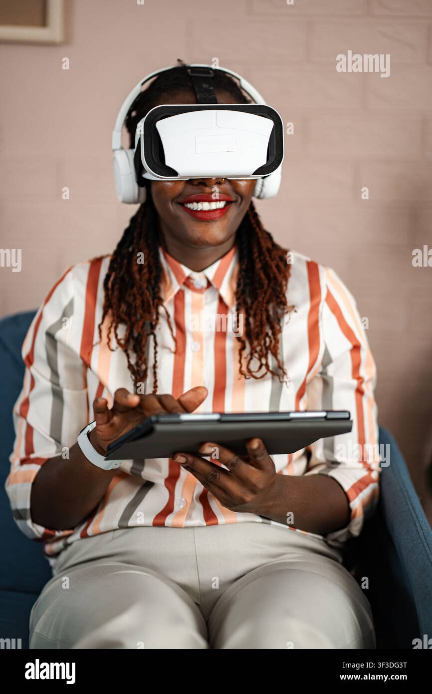 African American woman experiencing virtual reality using tablet Stock Photo